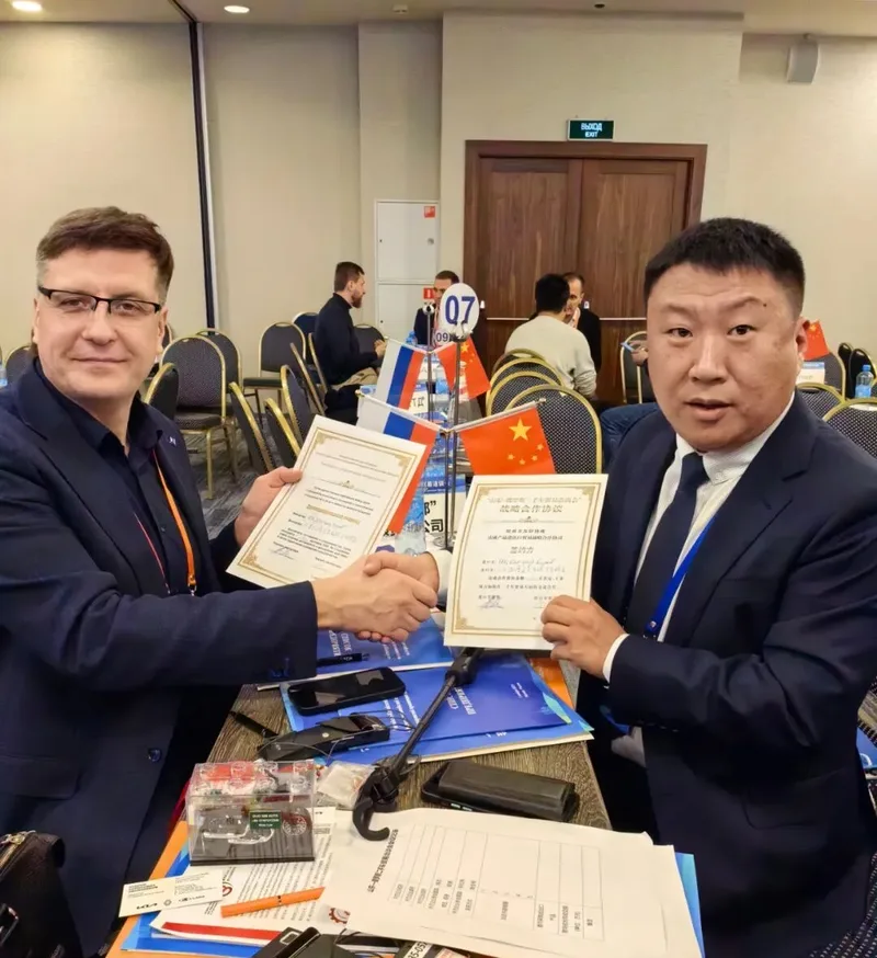 Two parties shaking hands over signed agreements